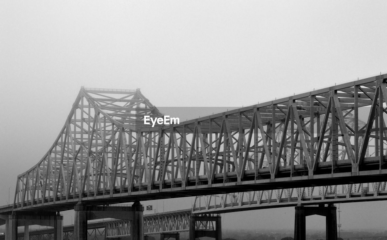 LOW ANGLE VIEW OF BRIDGE AGAINST CLEAR SKY IN CITY