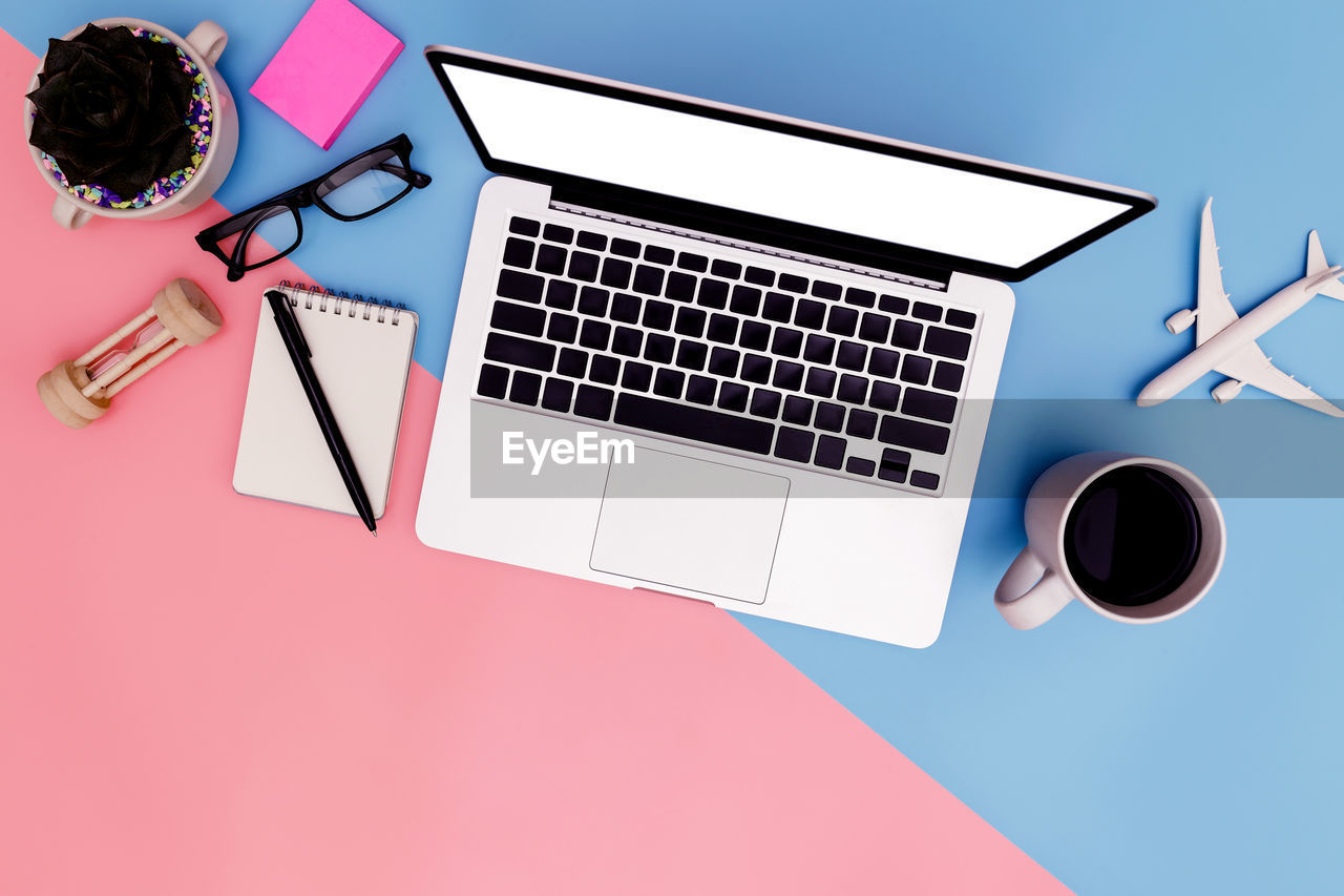 HIGH ANGLE VIEW OF COFFEE AND LAPTOP ON TABLE AT HOME