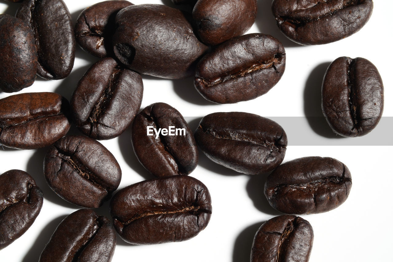 HIGH ANGLE VIEW OF COFFEE BEANS AND WHITE BACKGROUND