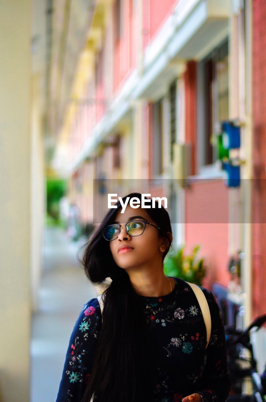 Young woman looking away while walking in lobby