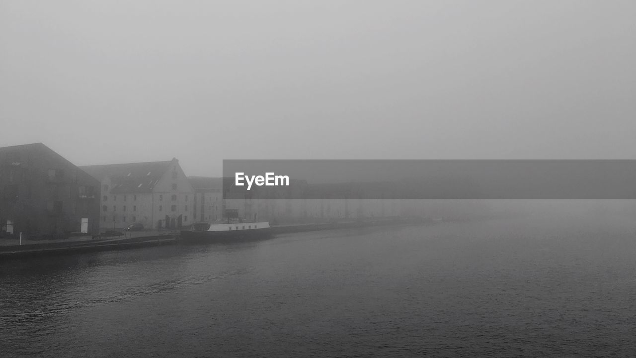 VIEW OF CITY AT WATERFRONT DURING FOGGY WEATHER