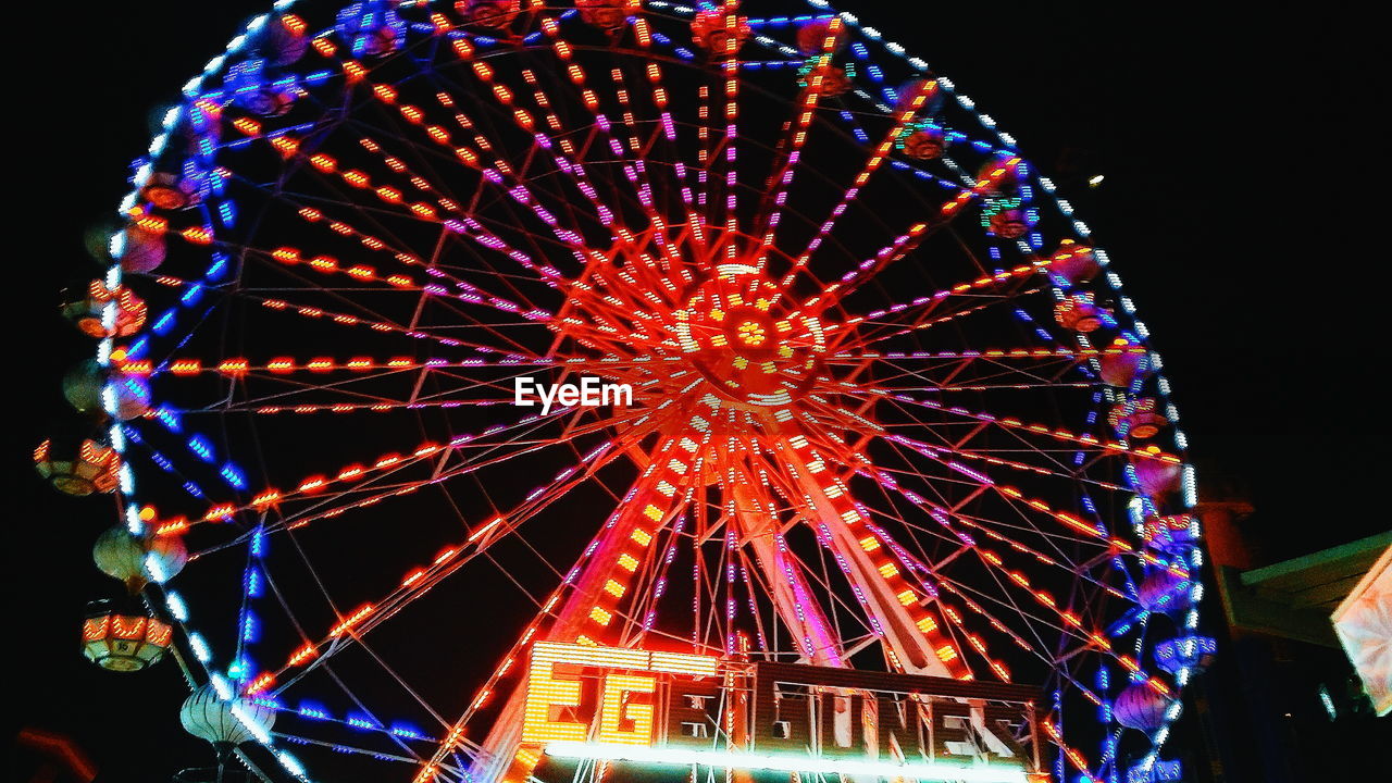 LOW ANGLE VIEW OF FERRIS WHEEL AT NIGHT