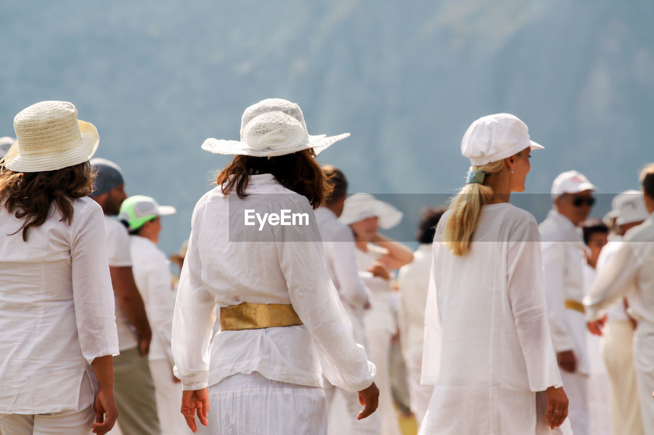 People wearing white clothes standing outdoors