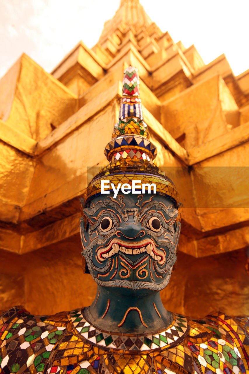 Close-up of sculpture outside temple against sky during sunset