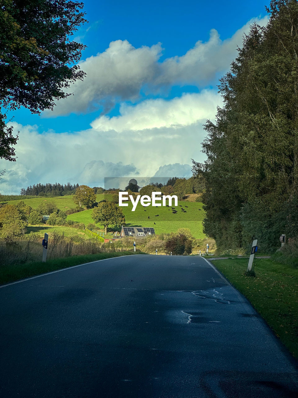 empty road amidst field against sky