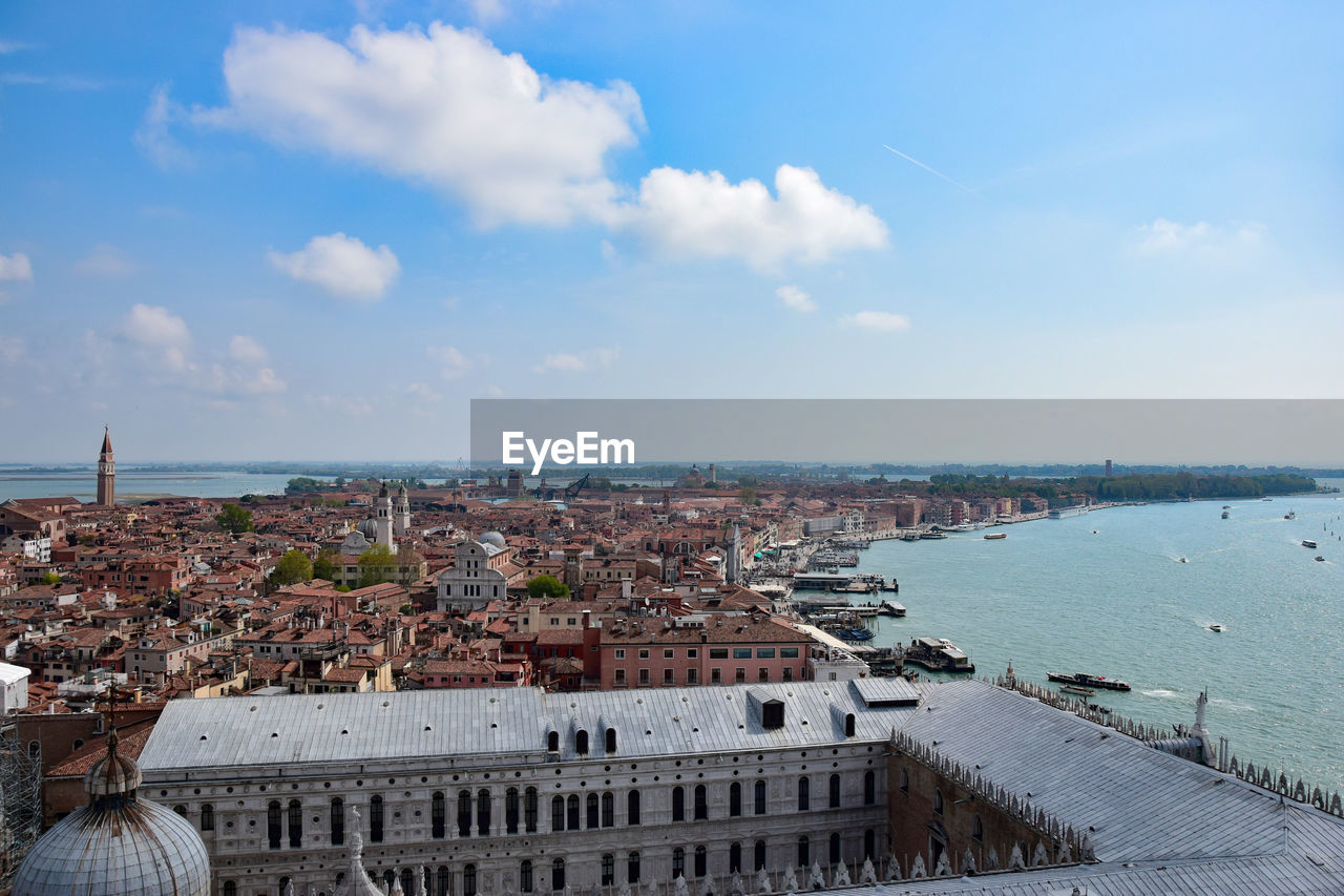 High angle view of townscape by sea against sky