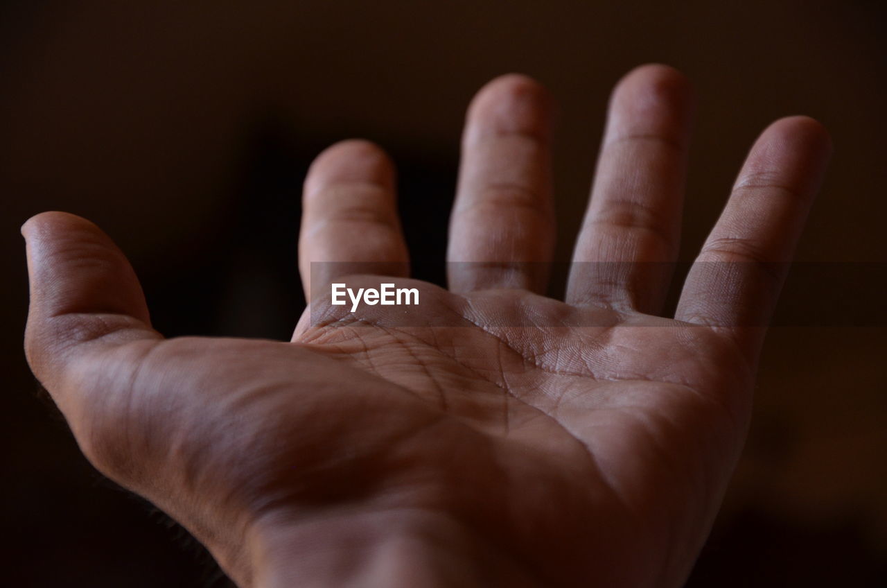 CLOSE-UP OF PERSON HAND AGAINST COLORED BACKGROUND