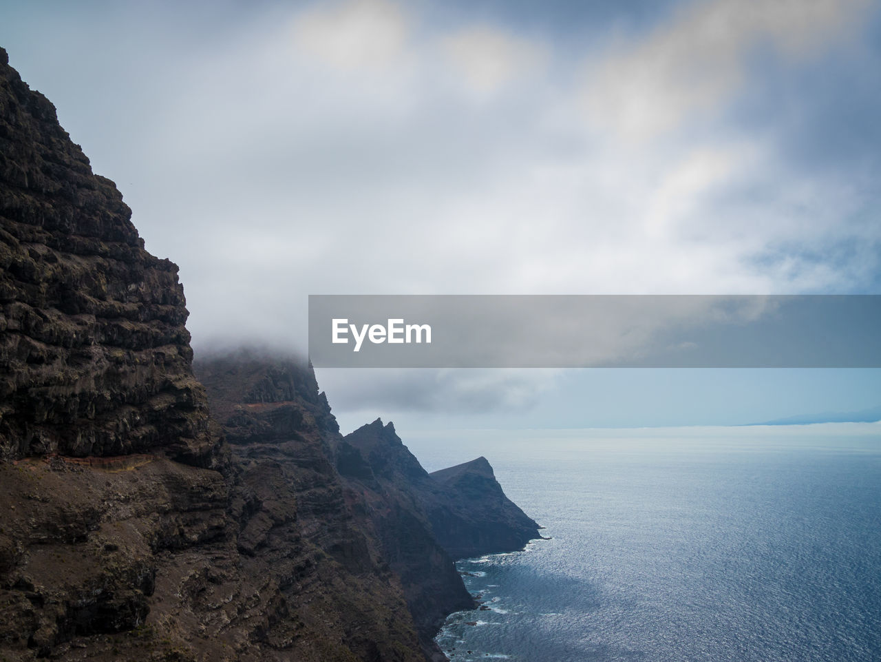 Rock formations by sea against sky