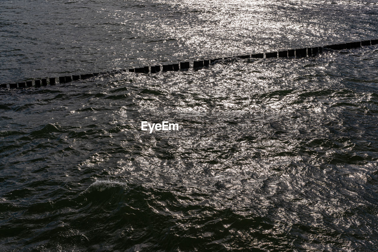 Rough sea with wooden poles