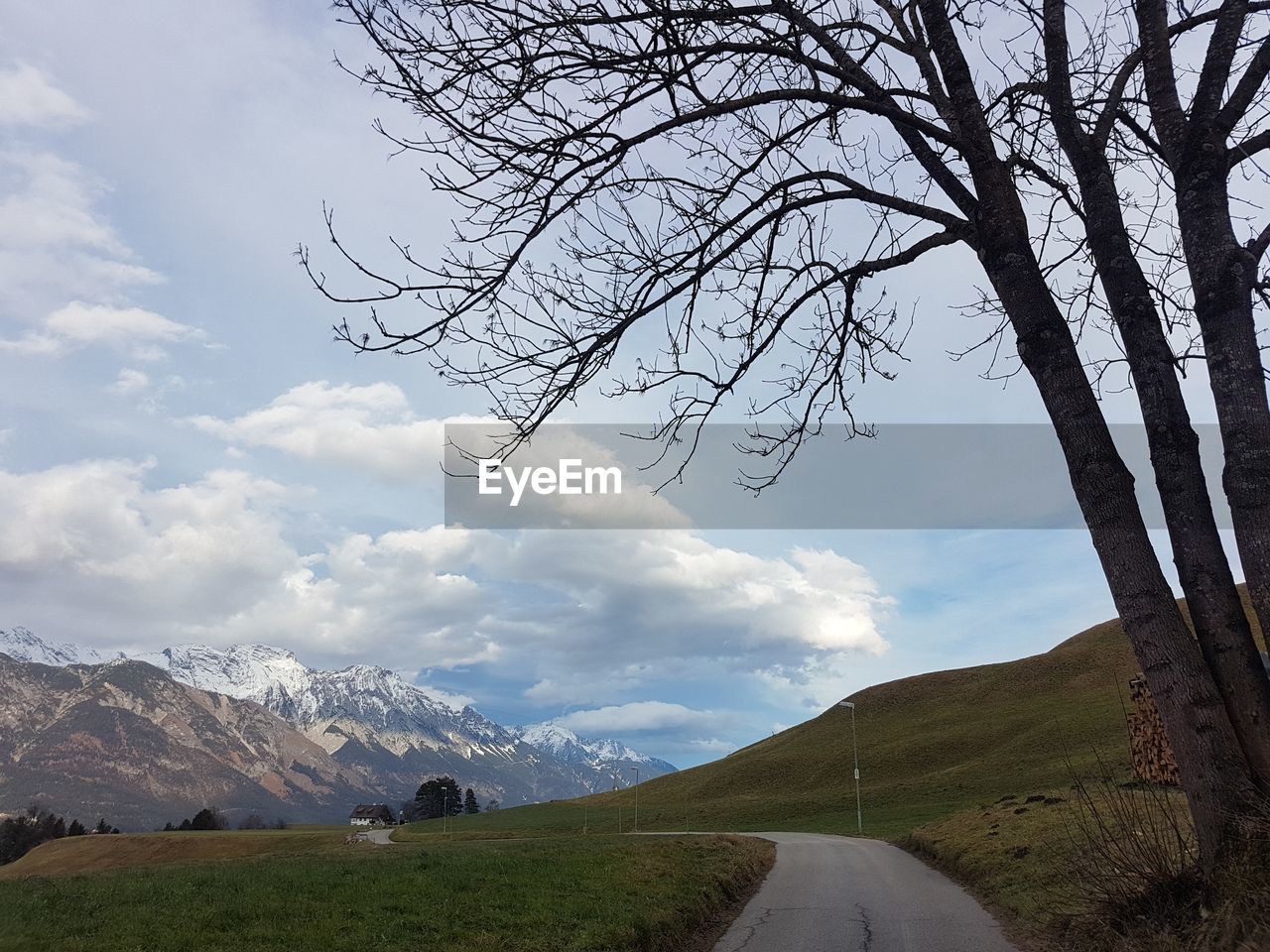 Scenic view of road by mountains against sky