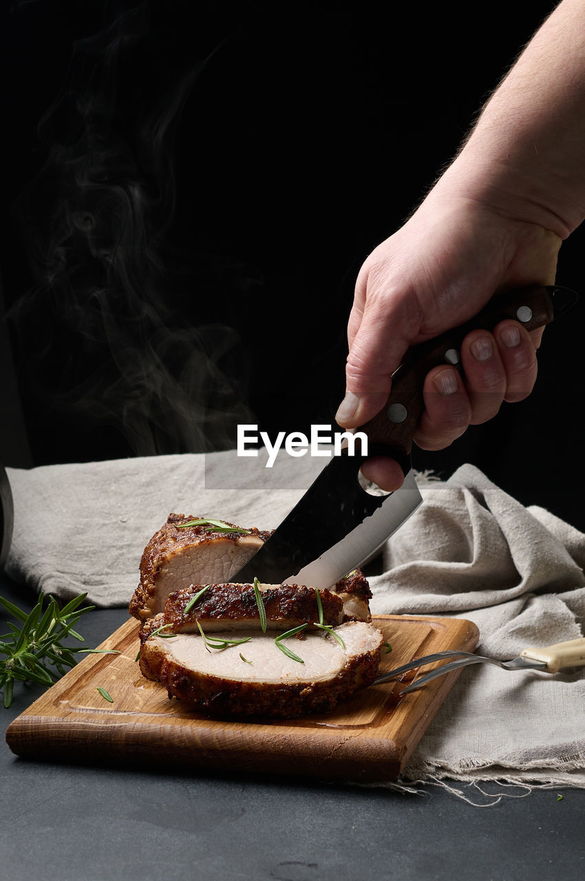 Baked piece of pork meat in spices on a wooden board, cut into pieces. eye of round roast steak