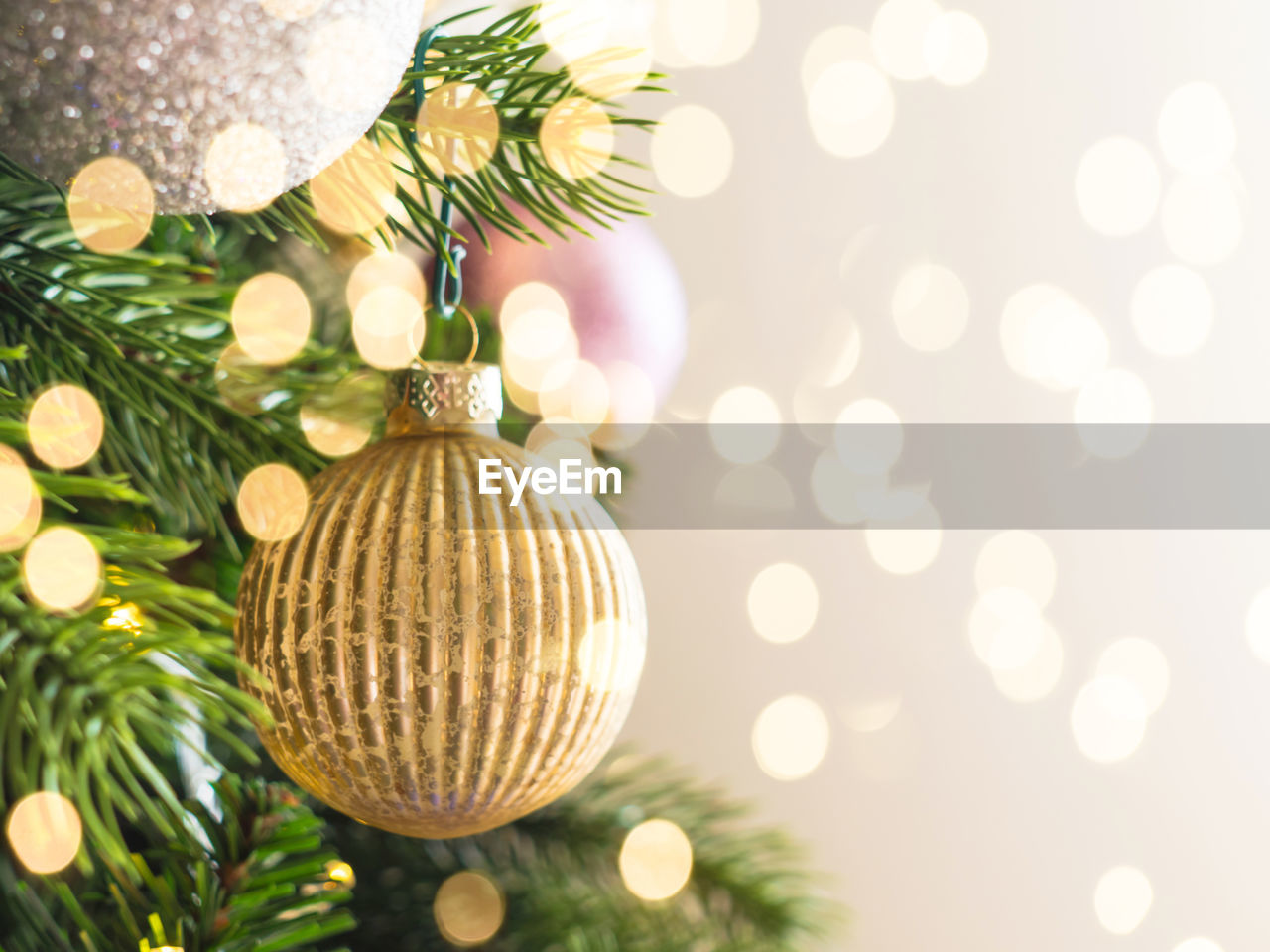 New year christmas tree background with golden ornaments and holiday lights bokeh