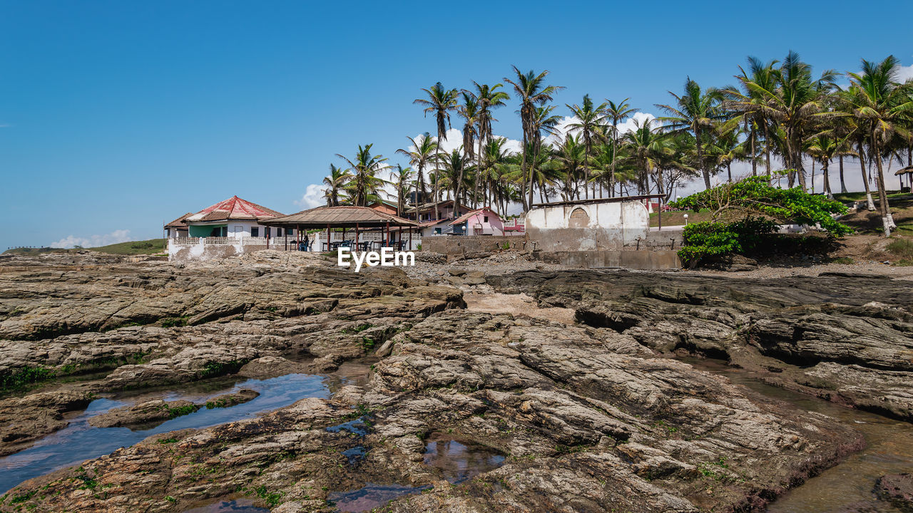 Views of the west african coast of ghana with palm trees and coastline buildings