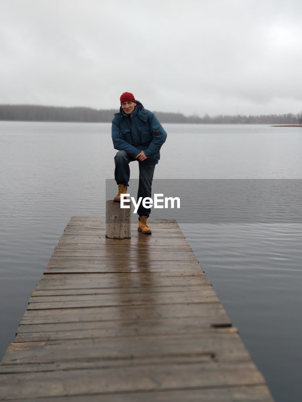 Full length of man standing on pier over lake against sky