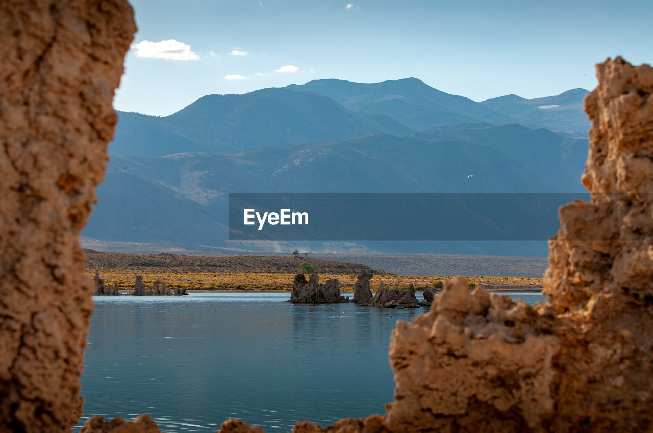 Scenic view of river and mountains against sky