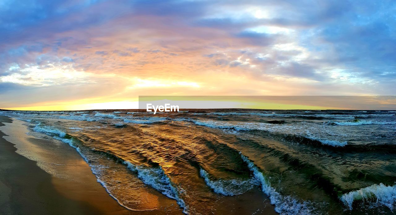 PANORAMIC VIEW OF BEACH AGAINST SKY DURING SUNSET