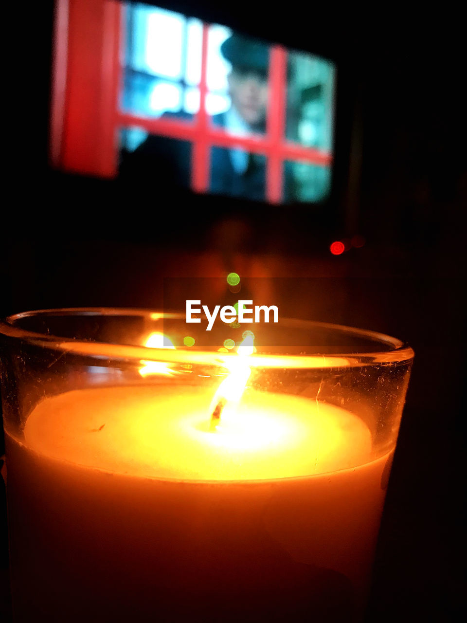 CLOSE-UP OF LIT CANDLE IN GLASS