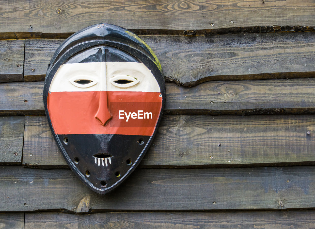 Close-up of mask hanging on wooden wall