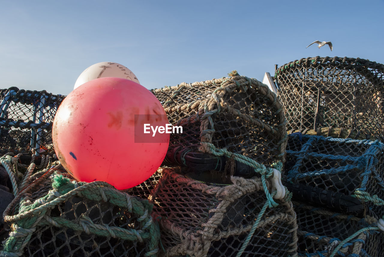 Close-up of fishing cages against sky