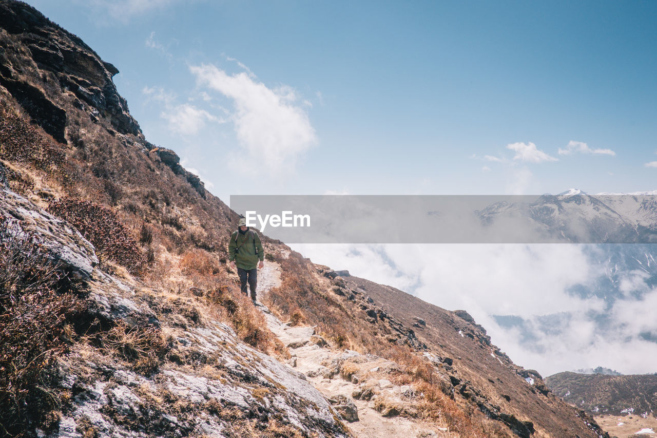 Man standing on mountain against sky