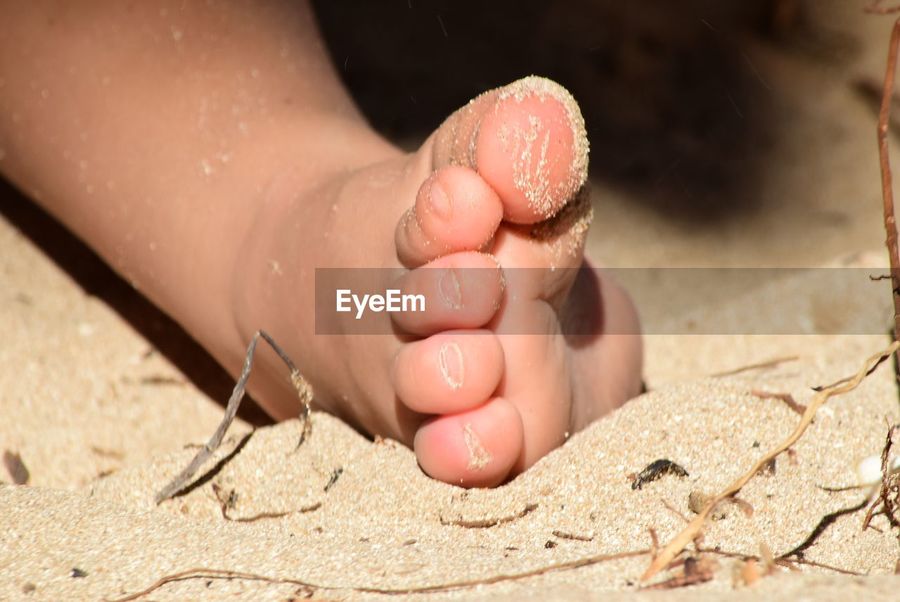 LOW SECTION OF WOMAN WITH BABY FEET