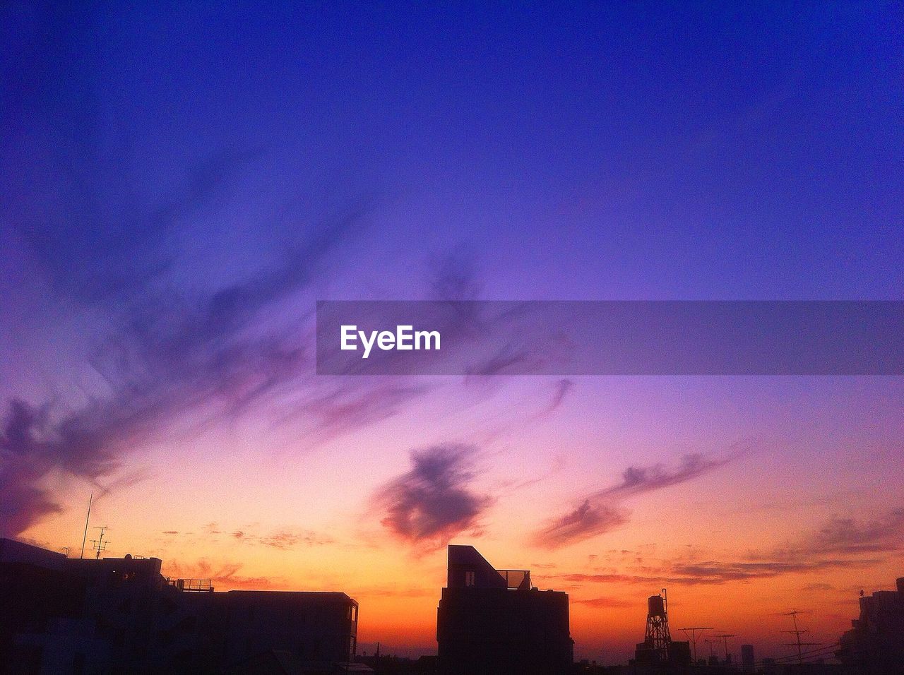 Low angle view of silhouette buildings against romantic sky