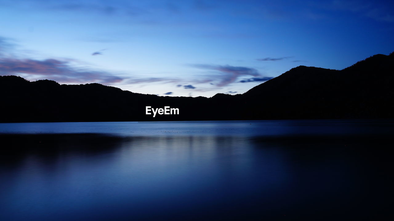 Scenic view of lake against sky at sunset