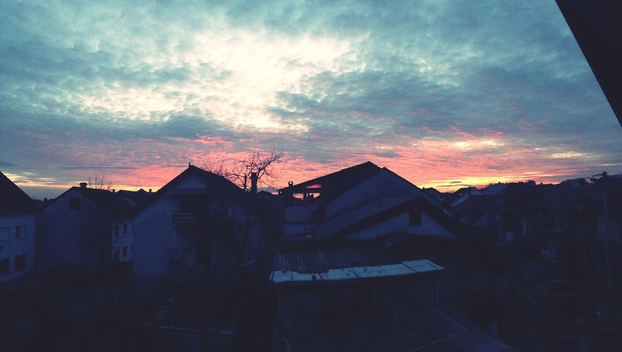 Exterior of houses against sky at sunset