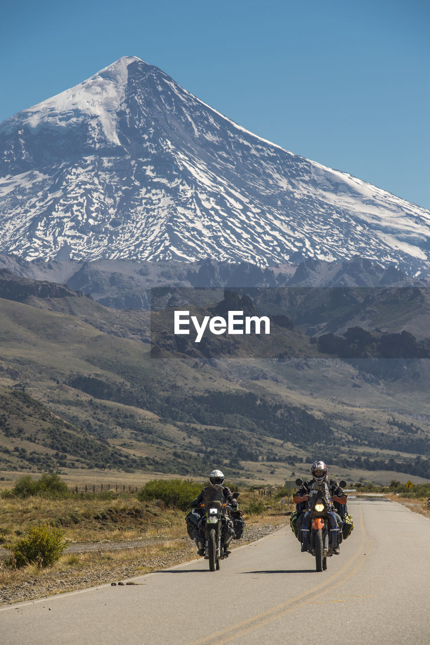 Couple on touring motorbikes. lanin volcano in the back, argentina