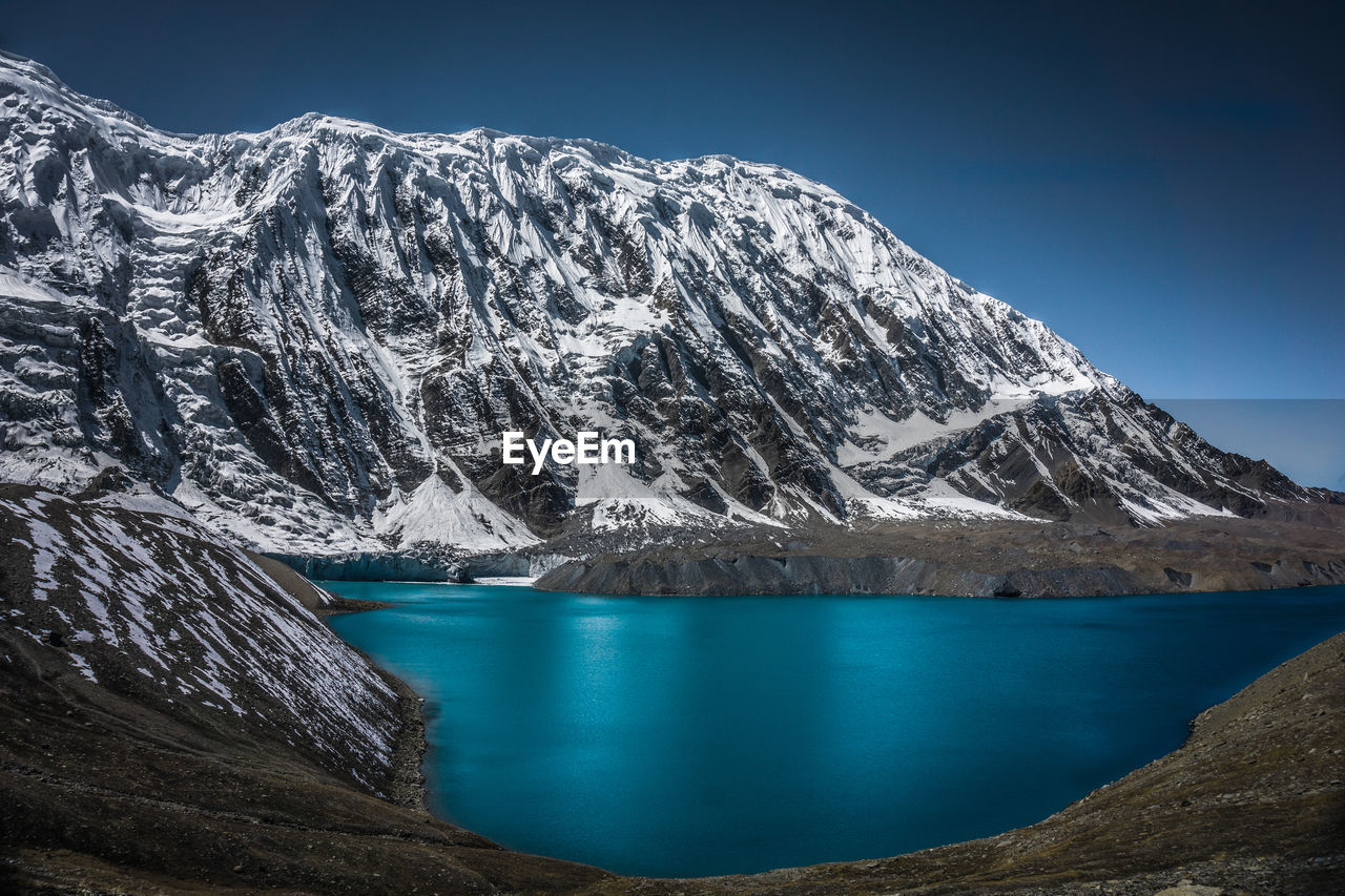 Scenic view of lake and snowcapped mountains against sky