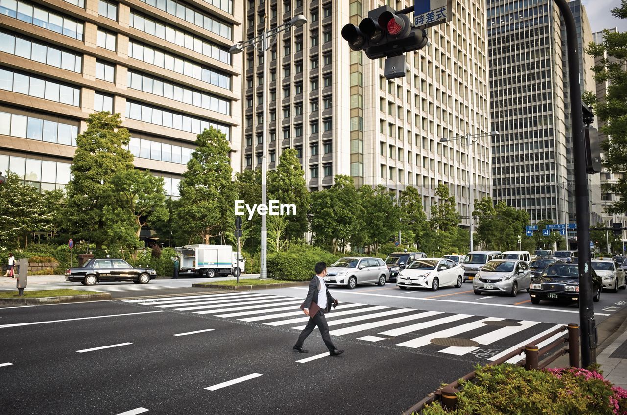 MAN CROSSING ROAD IN CITY