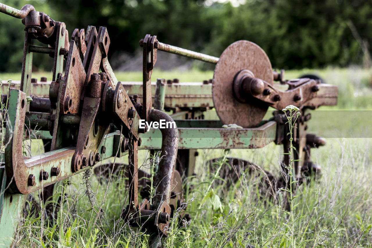 CLOSE-UP OF RUSTY CHAIN ON FIELD