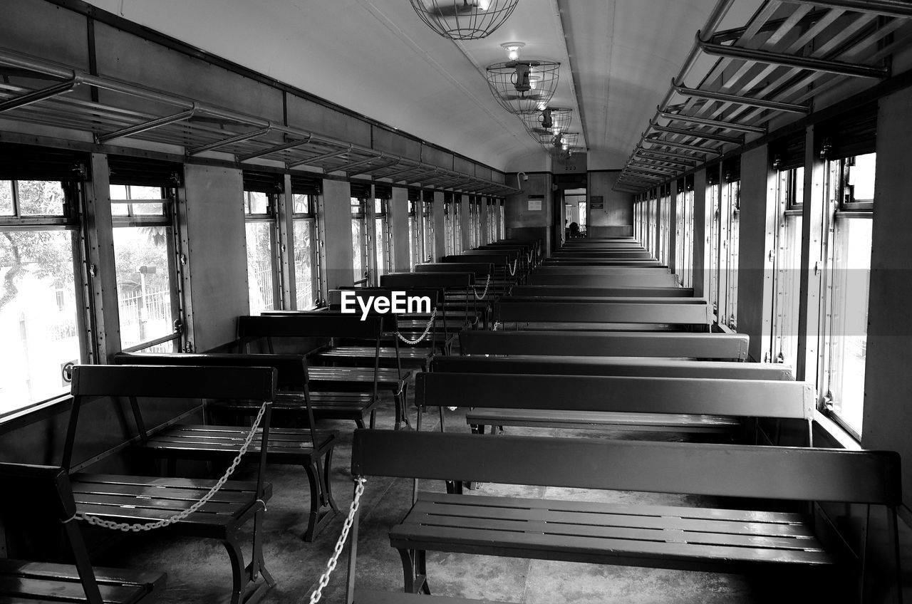 seat, indoors, black and white, transport, architecture, monochrome, no people, monochrome photography, transportation, interior design, day, absence, black, mode of transportation, built structure, in a row, vehicle, window, rail transportation, empty, chair, public transportation, public transport, train, vehicle seat