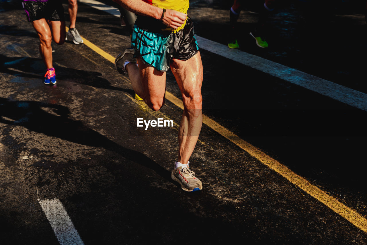 Low section of men running on road