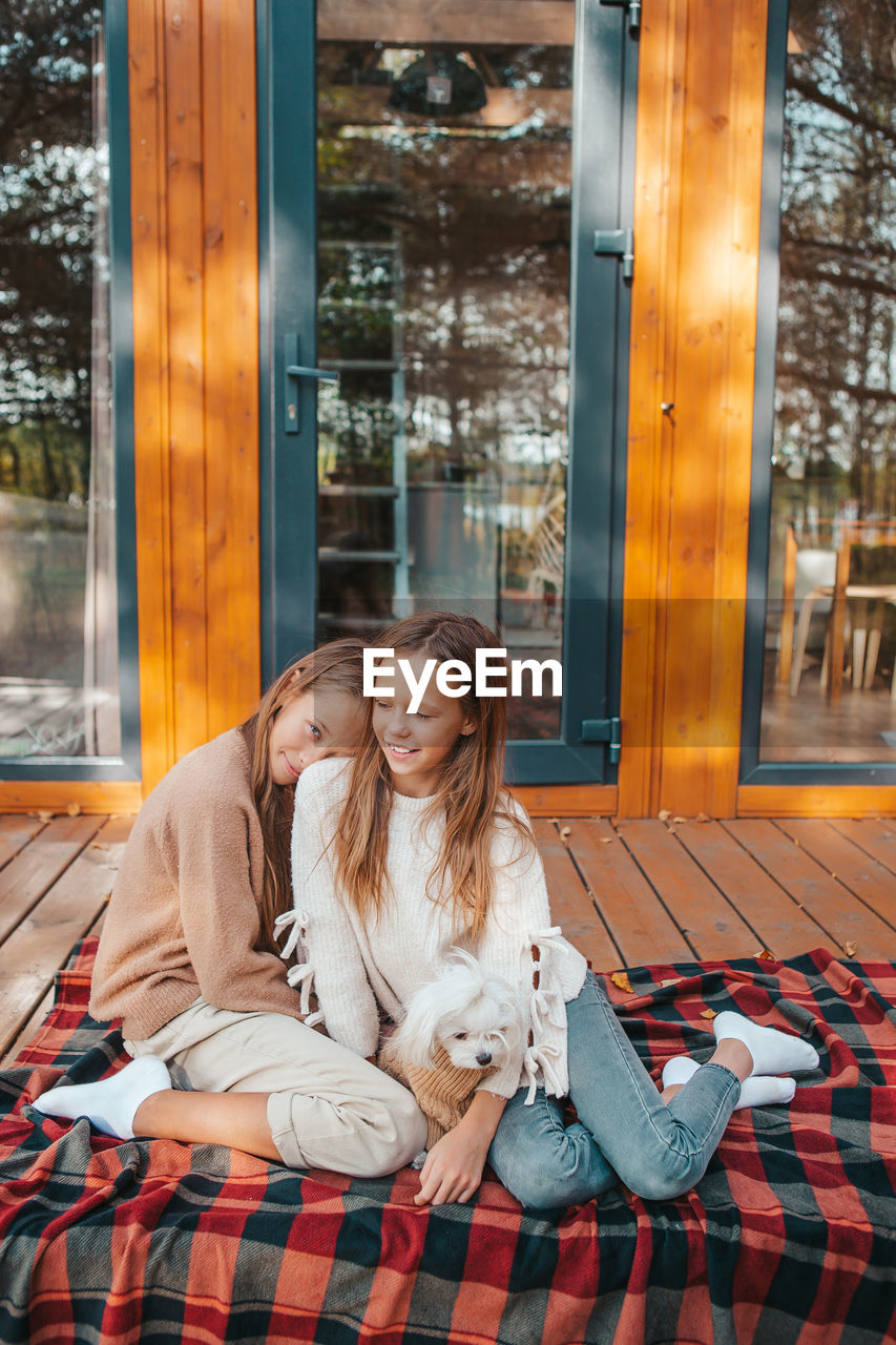 WOMAN WITH DOG SITTING ON FLOOR