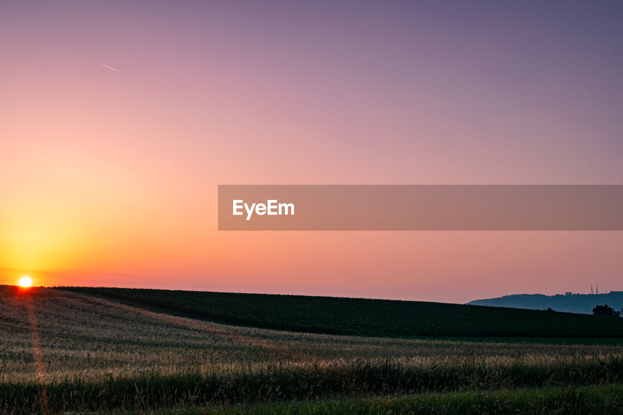 Scenic view of field against sky during sunset