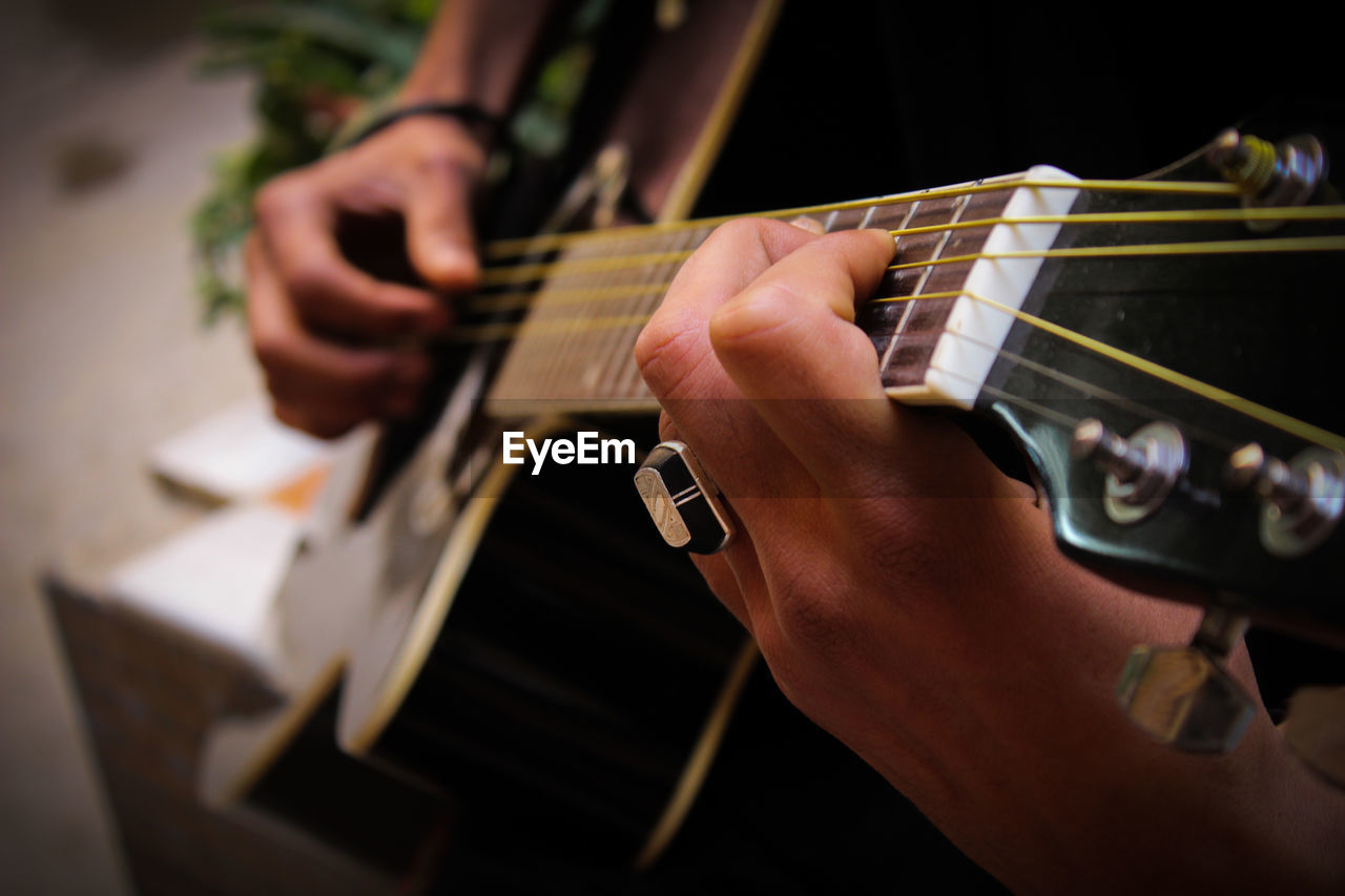 Cropped hands of man playing guitar