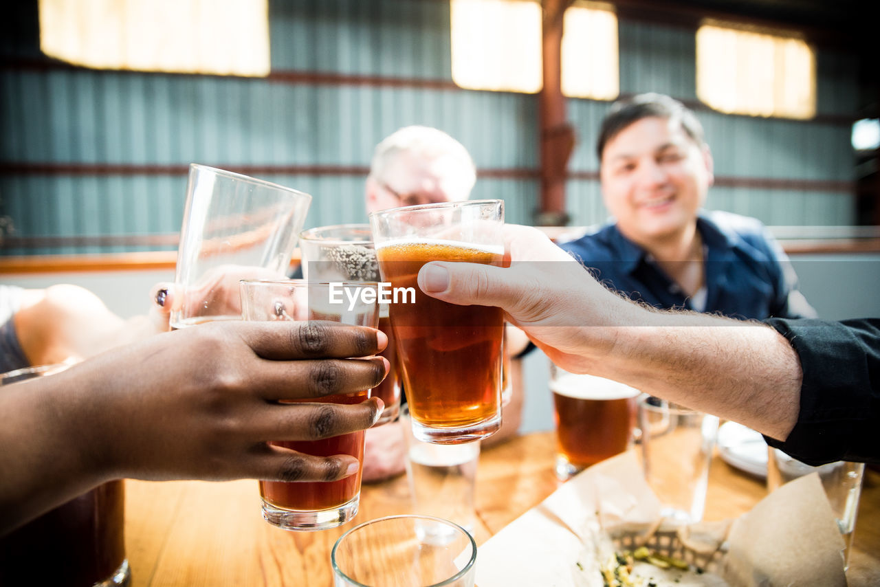 Close-up of people toasting with beer