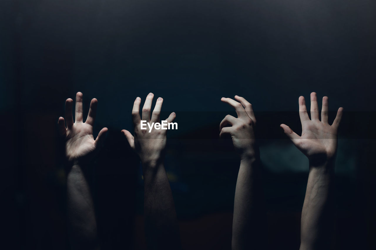 Cropped hands of people gesturing in darkroom