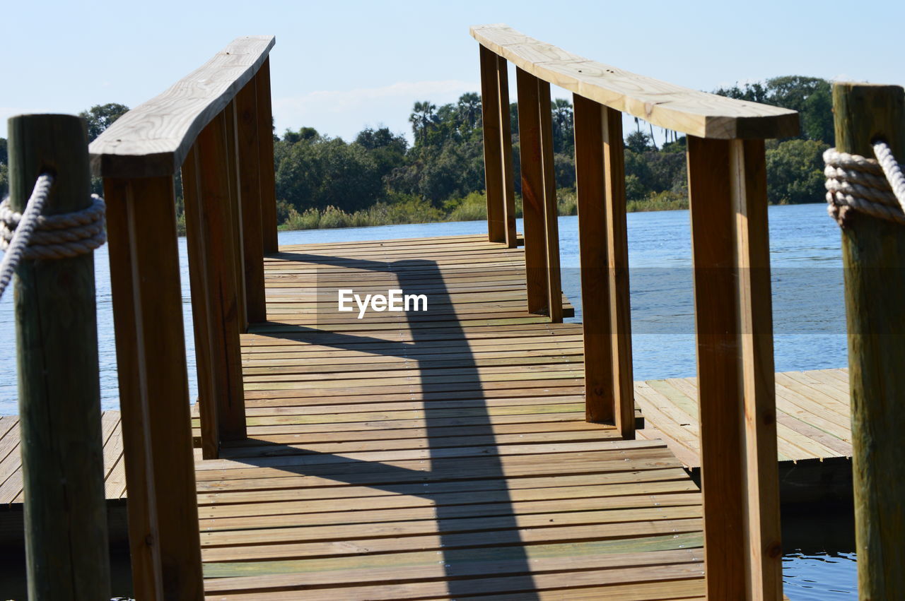 WOODEN POSTS IN LAKE AGAINST SKY