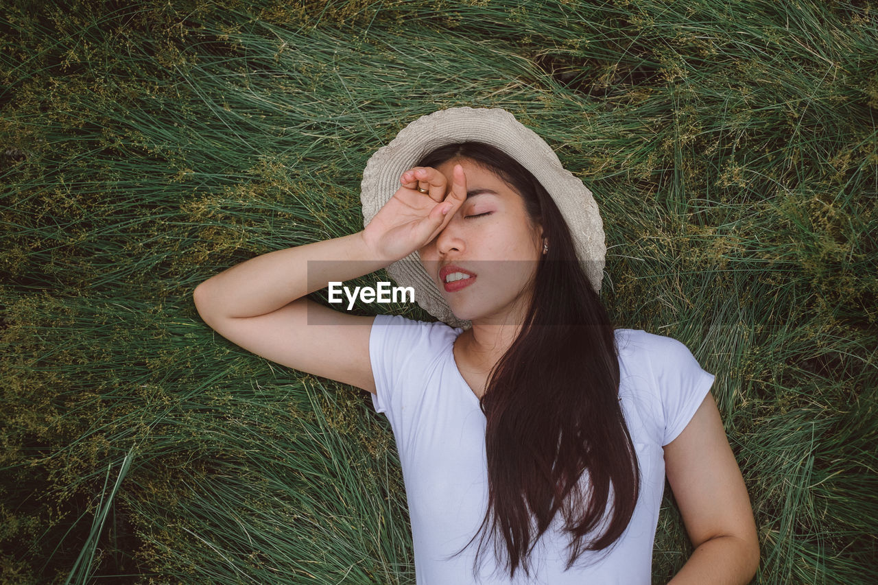 Beautiful young woman with eyes closed on field