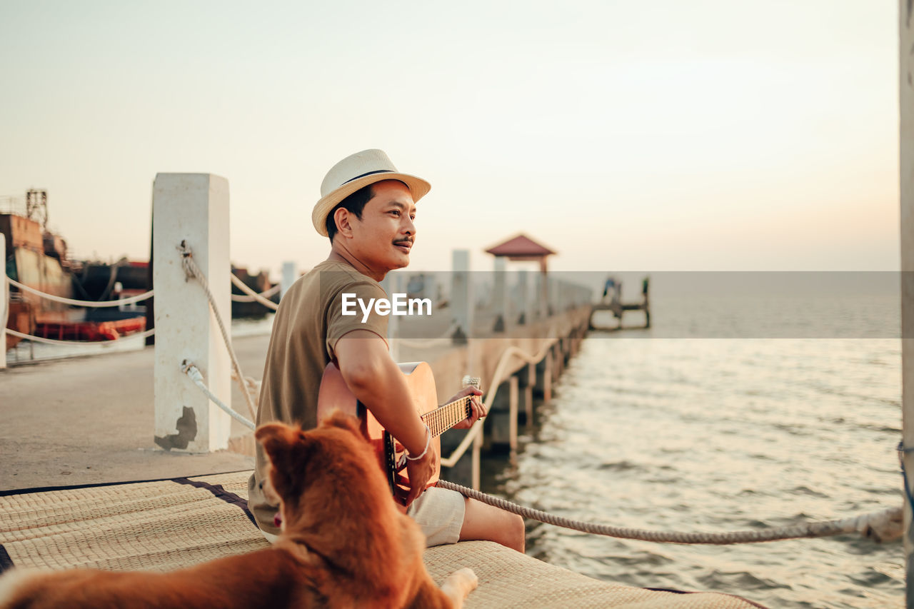 Full length of man on beach against sky during sunset