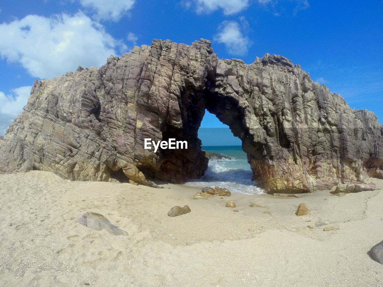 Rocks on beach against blue sky