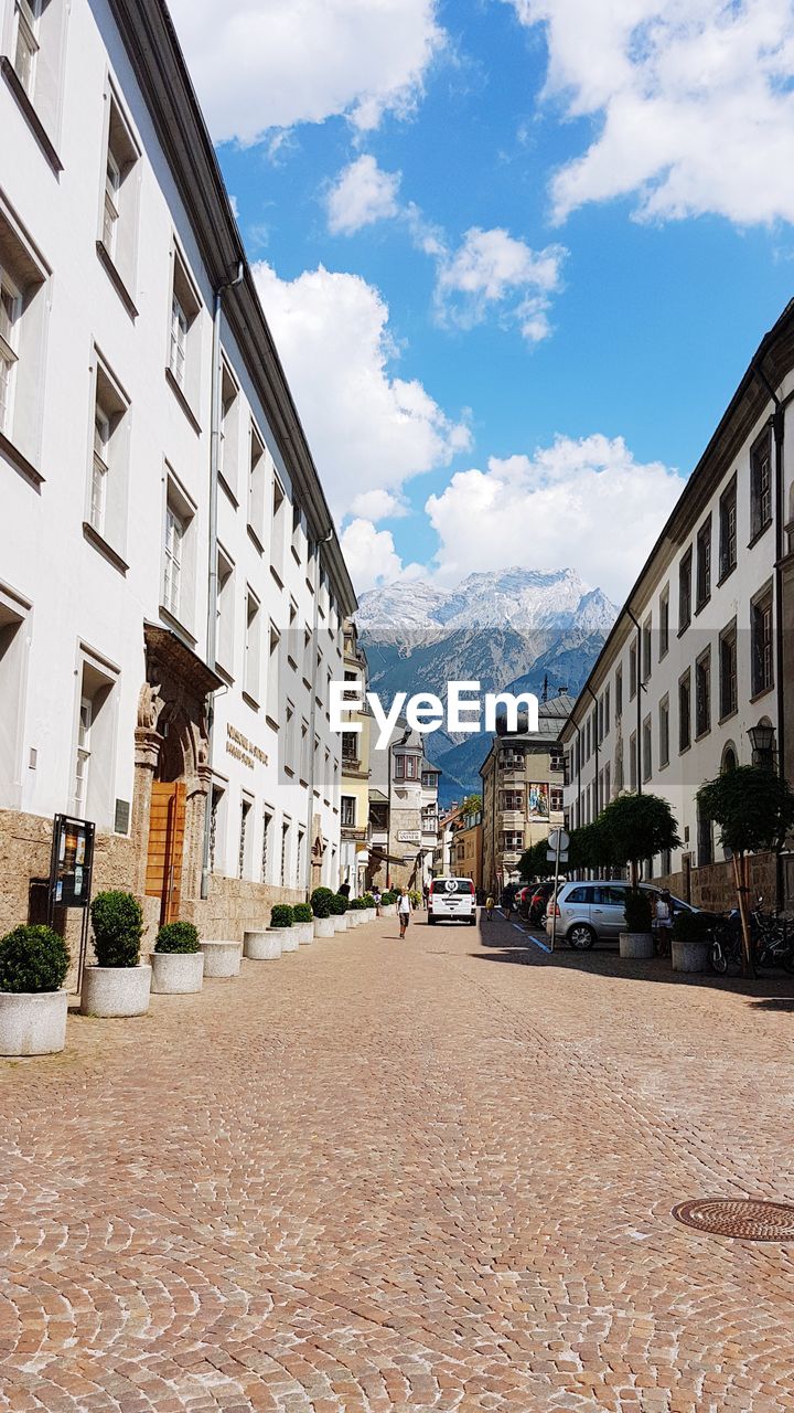 STREET BY BUILDINGS AGAINST SKY