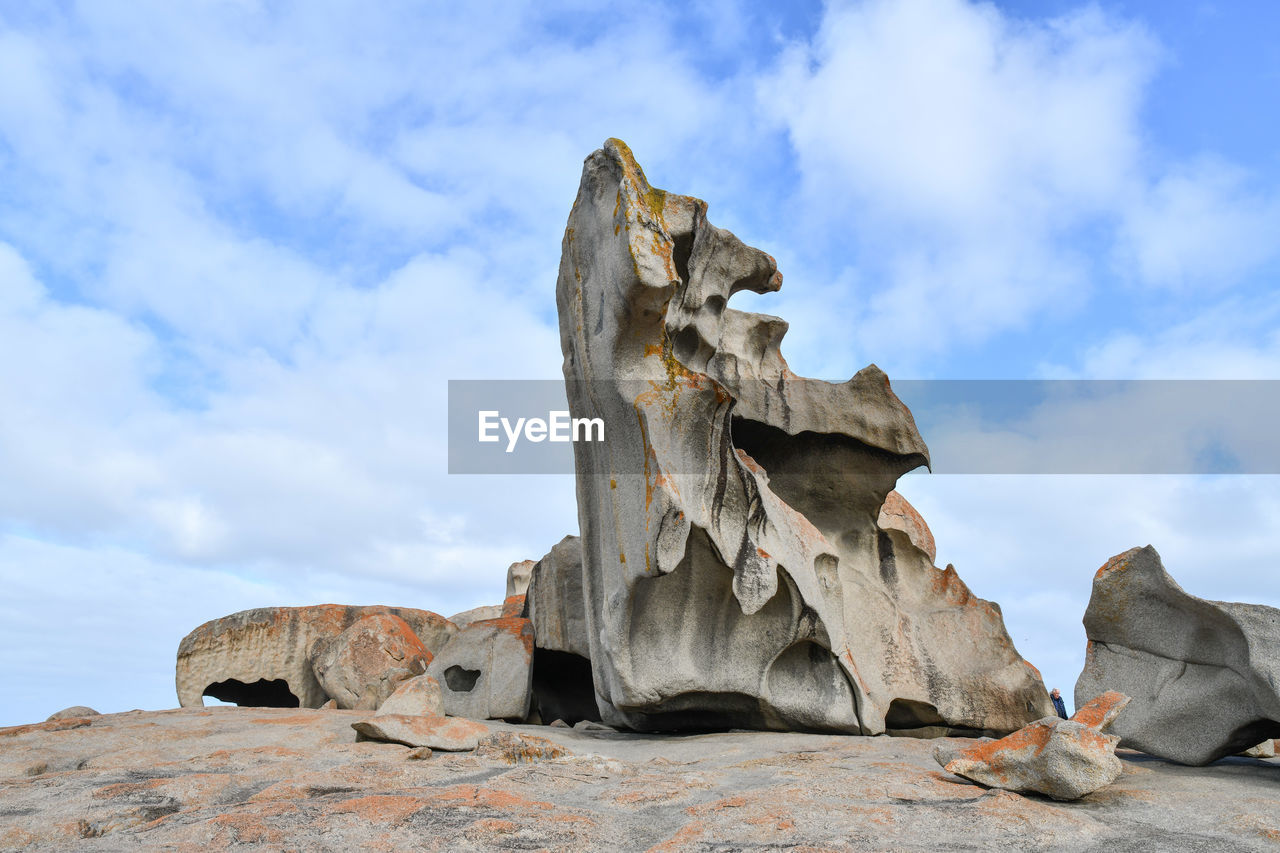 LOW ANGLE VIEW OF ROCK FORMATION AGAINST CLOUDY SKY