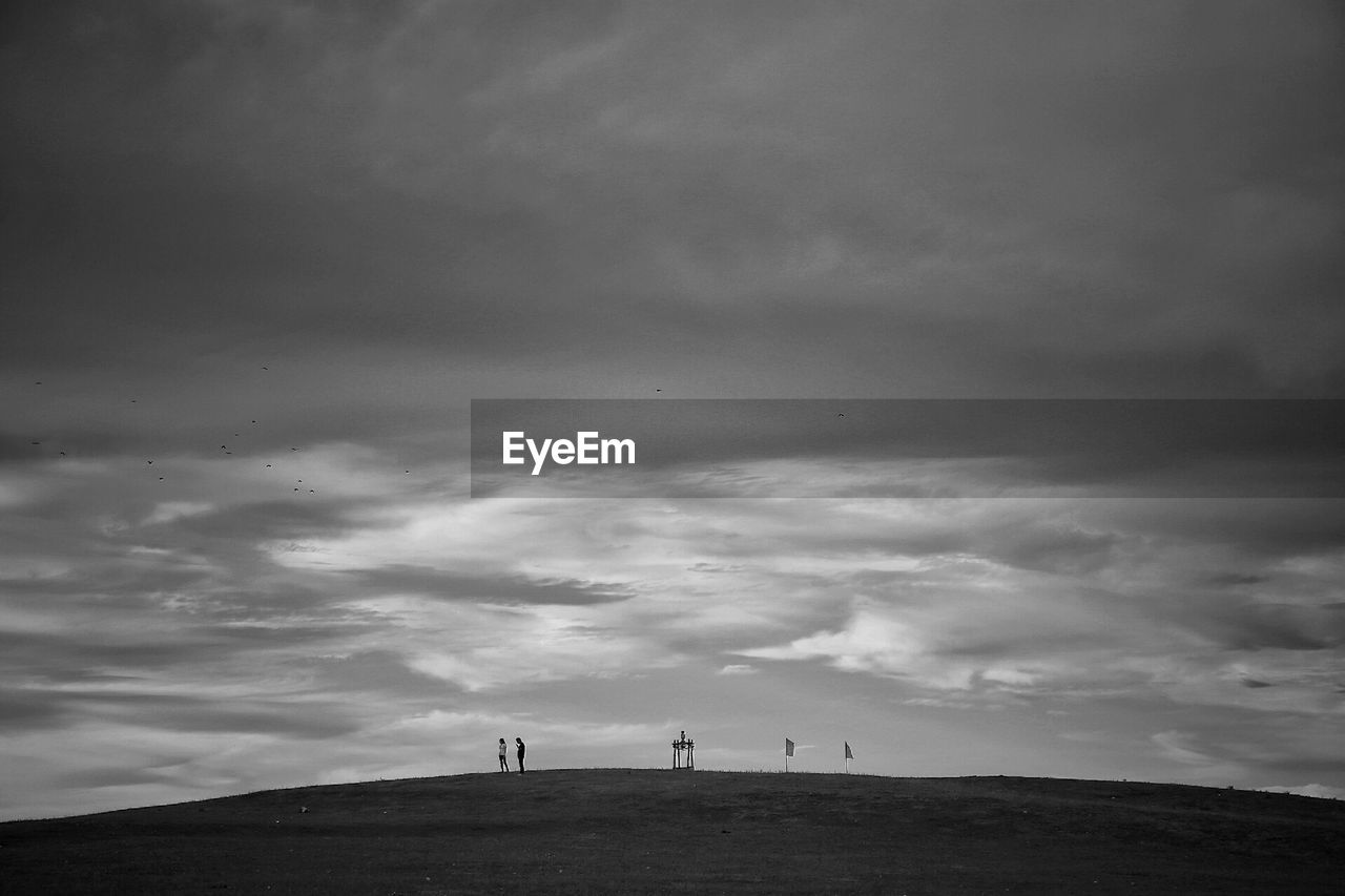 PEOPLE ON ROAD AGAINST SKY