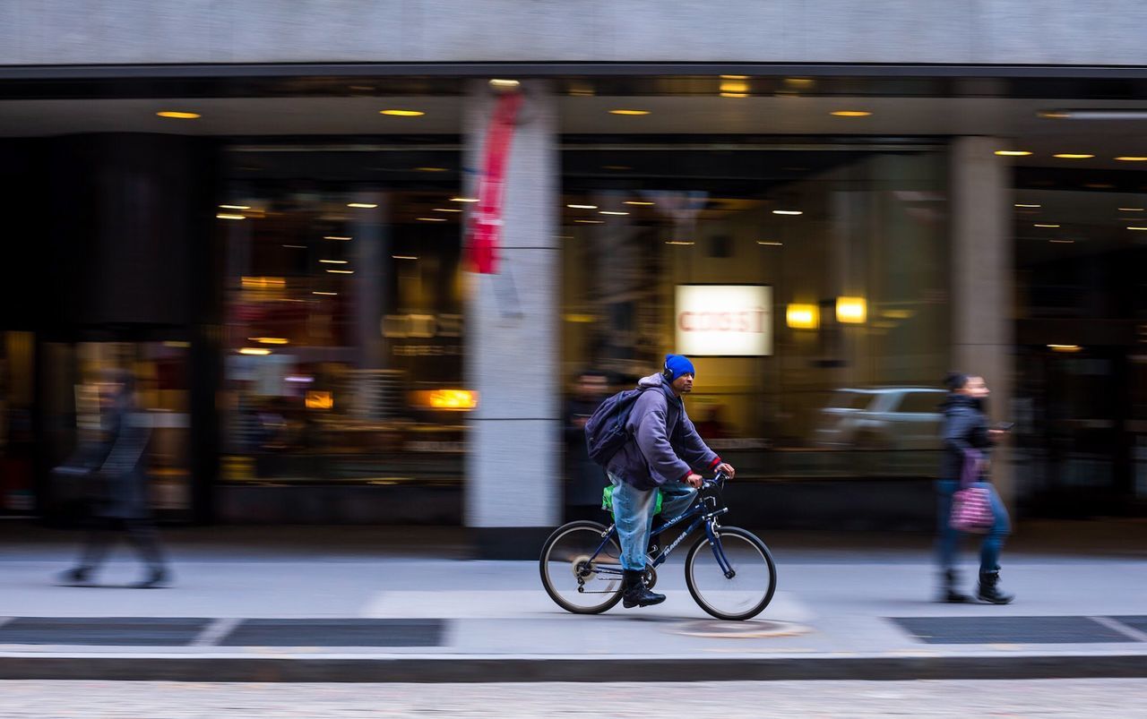 MAN CYCLING IN ILLUMINATED CITY