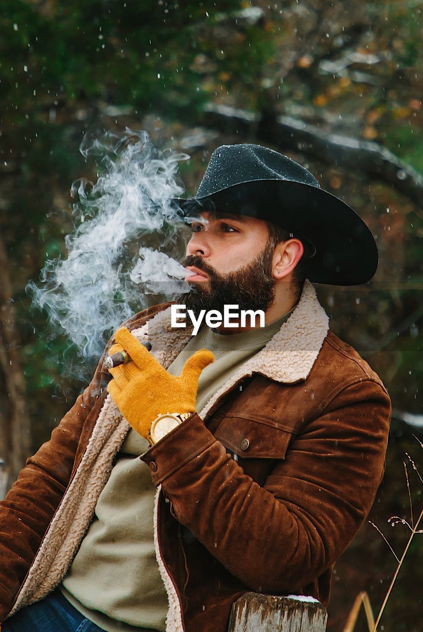 Man smoking cigar while standing outdoors