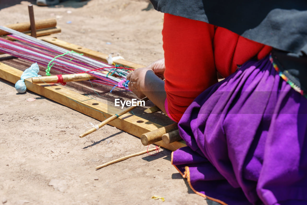 Midsection of woman making craft on field