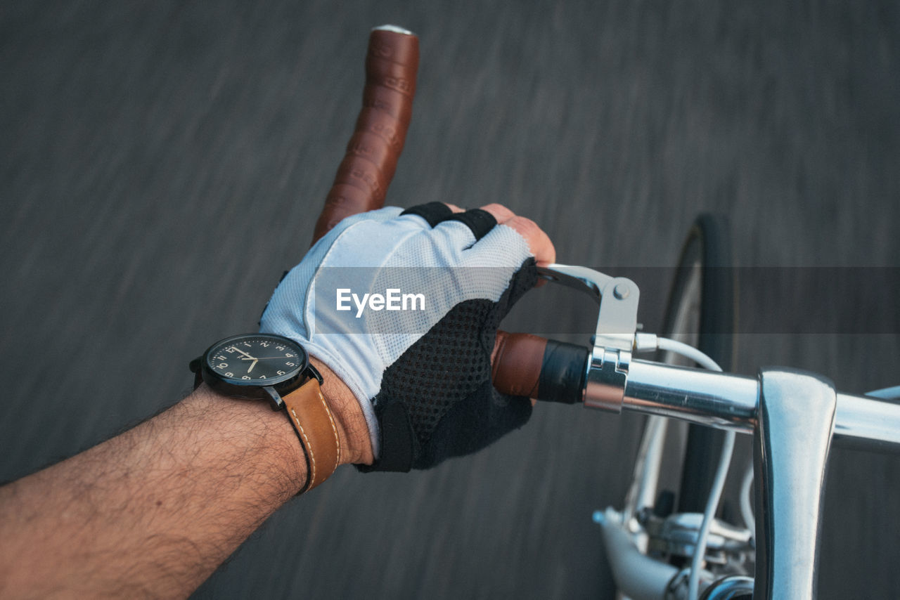 Cropped image of man riding bicycle on road